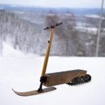 This wooden snow scooter is like a portable electric snowmobile that you stand on