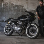 A side view of a Royal Enfield Continental GT 650 cafe racer with a man in a car park